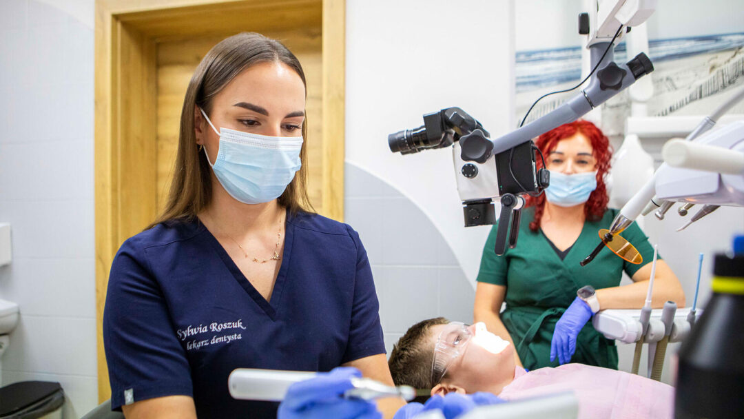 Lekarz stomatolog Nowa MED tłumaczący pacjentowi przebieg leczenia na modelu.